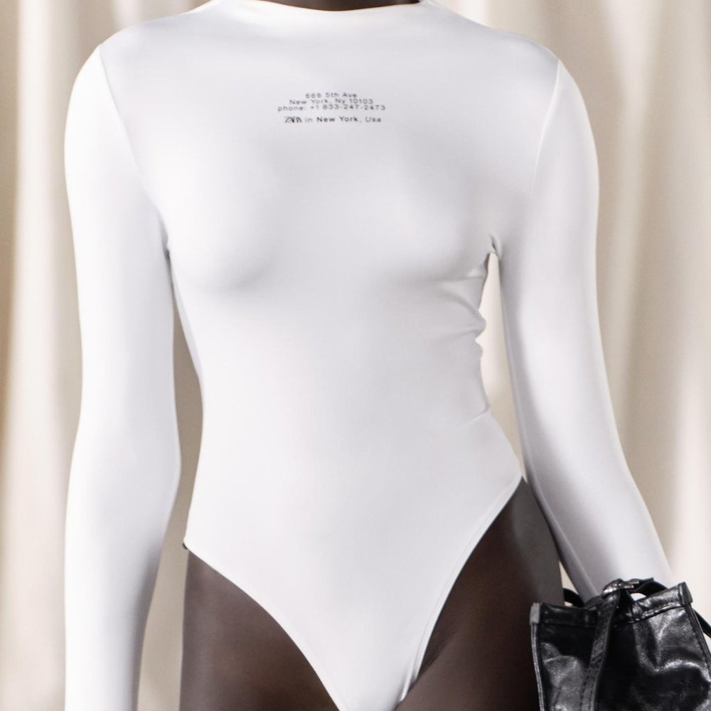 white bodysuit with black letter